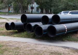 black industrial pipes stacked on grass near a str 2026 09 23 22 59 38 utc